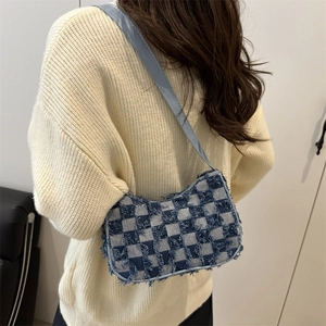 Sac sous les bras à carreaux bleus et beige avec texture effilochée sur l'épaule