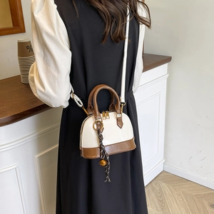 Retro shell-shaped crossbody bag in cream and caramel leather with bell pendant