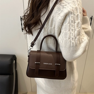 Dark brown leather messenger bag with top handle and adjustable shoulder strap for women