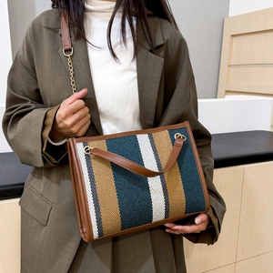 Chic striped large tote bag with chain strap and leather trim shown on model