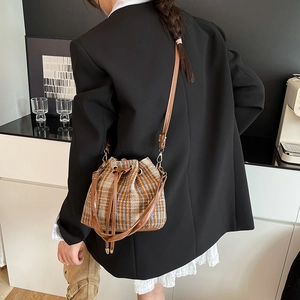 Borsa a secchiello retrò in tweed scozzese con coulisse, indossata da donna in blazer nero