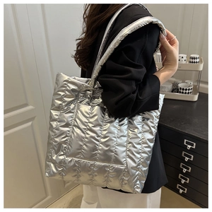 Detail of silver metallic quilted tote bag with soft down-padded nylon fabric for women