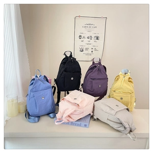 Sechs Farben leichter Nylon-Rucksäcke auf einem Tisch für einen minimalistischen Reisestil