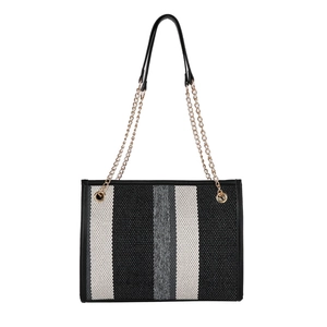 Striped woven tote bag with black leather handles and gold chain strap on white background