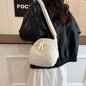 Minimalist cream corduroy shell messenger bag with double zippers and wide shoulder strap