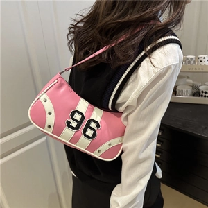 Pink crescent hobo bag with number 96 embroidery and metal rivets shown on shoulder