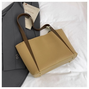 Dettaglio borsa shopper beige in pelle martellata con manici marroni e piedini dorati