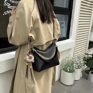 Retro zwarte hobo schoudertas in maanvorm met een schattige schaap hanger als detail