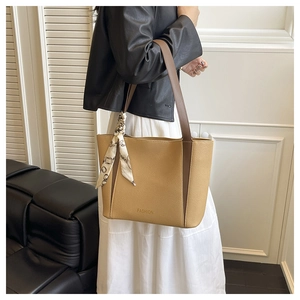 Dettaglio della borsa tote color cammello con trama litchi, stampa moda e foulard in seta