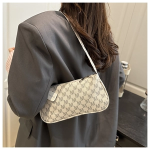 Detailed close-up of a crescent underarm bag featuring grey letter print and silver zipper