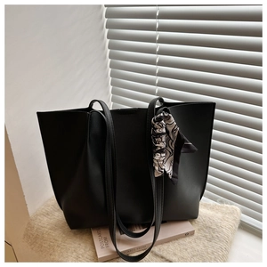 Detail of black pleated tote bag with patterned silk scarf and long shoulder straps