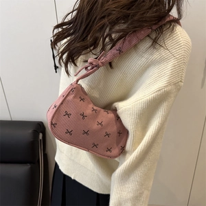 Sac à bandoulière en velours rose avec motifs nœuds noirs et sangle nouée