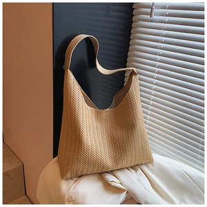 Détail du sac hobo tissé marron clair montrant la texture à chevrons et la bandoulière