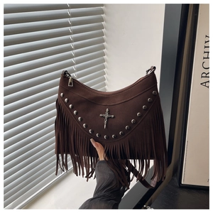 Detail of dark brown matte crescent bag with metal rivets, skull cross and long fringe