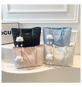 Detail of embroidered star-patterned tote bags with cute cloud charms in various soft colors