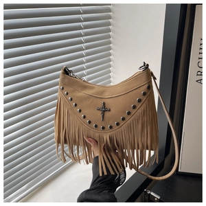 Close-up of khaki suede handbag featuring punk rivets, metal cross and long tassels detail