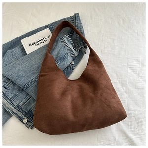 Dettaglio della borsa tote in pelle scamosciata marrone scuro con design retrò traforato