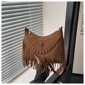 Detail of brown suede crescent bag with silver studs, metallic cross and long fringes