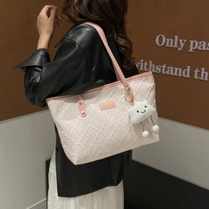 Pink bohemian tote bag with textured surface and cloud plush charm for casual style