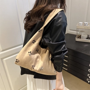 Elegante borsa tote in pelle scamosciata marrone chiaro traforata indossata a spalla