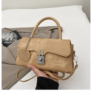 Dettaglio della borsa vintage kaki con chiusura in metallo argento e ciondolo alla moda