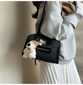 Close-up of black polka dot backpack with silver metal logo and plush puppy charm