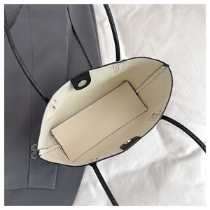 Interior view of black woven tote bag with magnetic clasp and reinforced cream lining