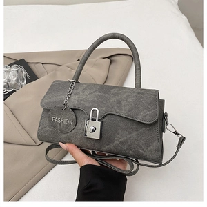 Dettaglio della trama denim grigia e della chiusura in metallo su una borsa vintage