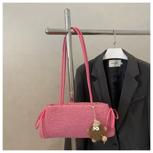 Détail du sac cabas en peluche rose avec breloque et nœud à cordon de serrage latéral
