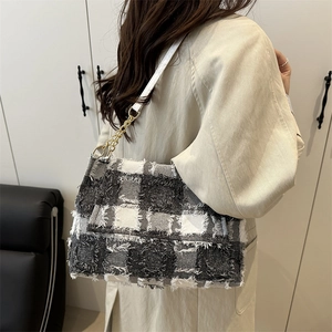 Fashionable black and white tweed plaid crossbody bag with gold chain and fringe details