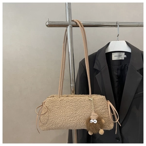 Détail du sac fourre-tout en peluche beige avec pendentif monstre et cordon décoratif