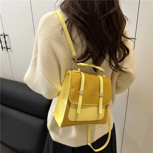 Zaino alla moda giallo in ecopelle con trama a coccodrillo indossato da una modella