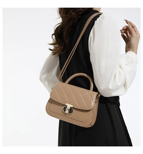 Detail van kaki gewatteerde handtas met elegante gouden draaisluiting en stevig handvat
