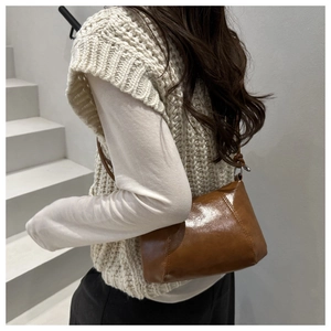 Vue détaillée arrière d'un sac à bandoulière rétro en cuir marron brillant au design épuré