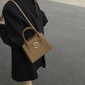 Brown leather handbag with M-pattern jacquard and gold logo shown on model back view
