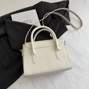 Chic white square crossbody bag with dual handles and slim shoulder strap detail