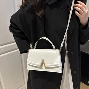 Sac à main carré blanc style français avec boucle en A dorée porté par un mannequin