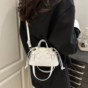 Mini sac à main blanc à motif crocodile avec bandoulière amovible porté par un mannequin