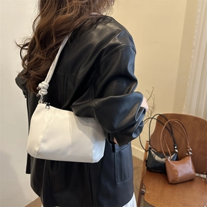Sac hobo minimaliste en similicuir avec détail de nœud présenté dans un studio élégant