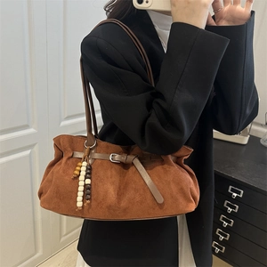 Caramel suede crossbody bag with colorful bead tassel and leather strap in mirror selfie