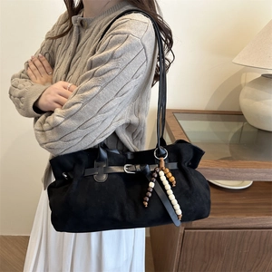 Retro black crossbody bag with matte finish featuring wooden bead tassels and buckle detail