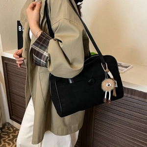 Retro black suede tote bag for women with minimalist design and plush charm accessory