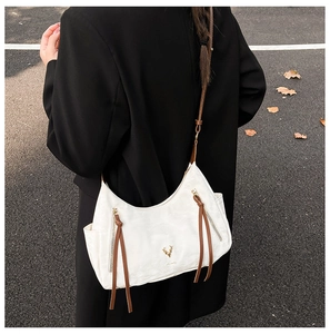 Détail du grand sac cabas blanc avec logo cerf doré et accents en cuir marron