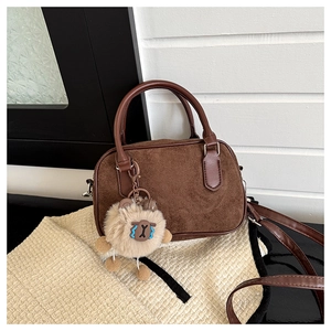 Détail du sac Boston en daim marron au style vintage avec charm en peluche mignon