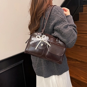 Dark brown leather shoulder bag with lace bow and dual front pockets for women