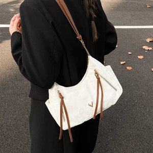 Sac bandoulière blanc style français avec lanières brunes et logo élan pour trajet