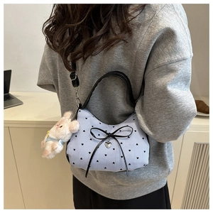 Détail du sac en toile rayé bleu avec motifs de cœurs et un charmant porte-clés ours