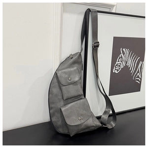 Detailed view of the vintage grey PU leather chest bag with functional snap pockets