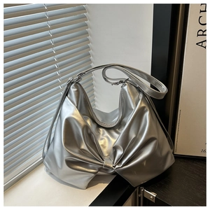 Detail shot of the metallic silver hobo bag featuring a unique front bow decoration