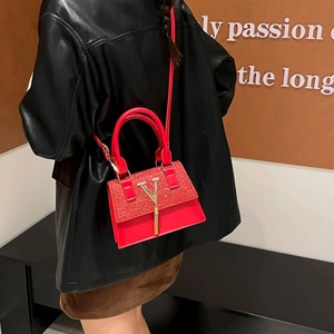 Borsa a tracolla rossa con paillettes e ciondolo a V dorato indossata da modella in pelle